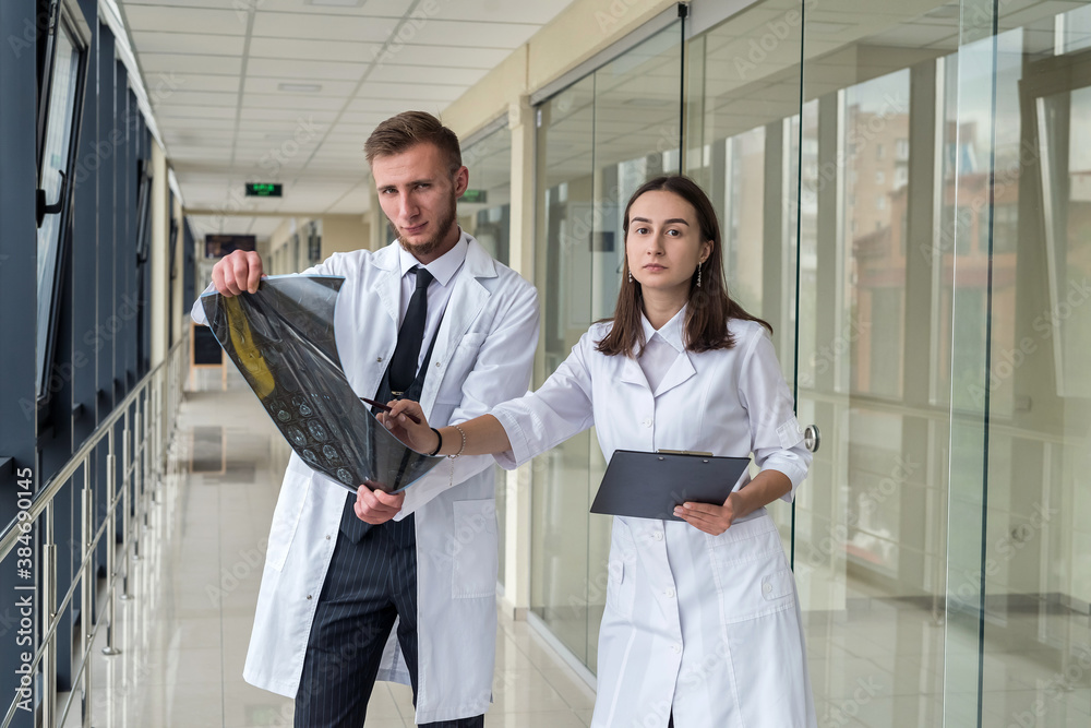 Two healthcare professionals looking at x-ray image, mri brain of patient for diagnosis Two healthcare professionals looking at x-ray image, mri brain of patient for diagnosis