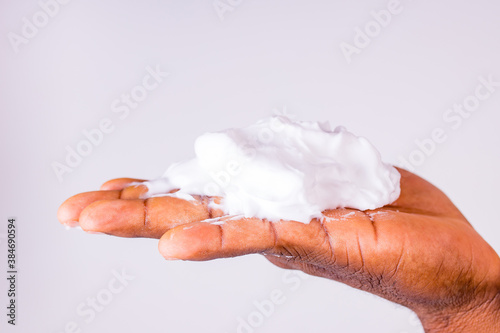 African man holds and show a piece of wet soap in studio white background