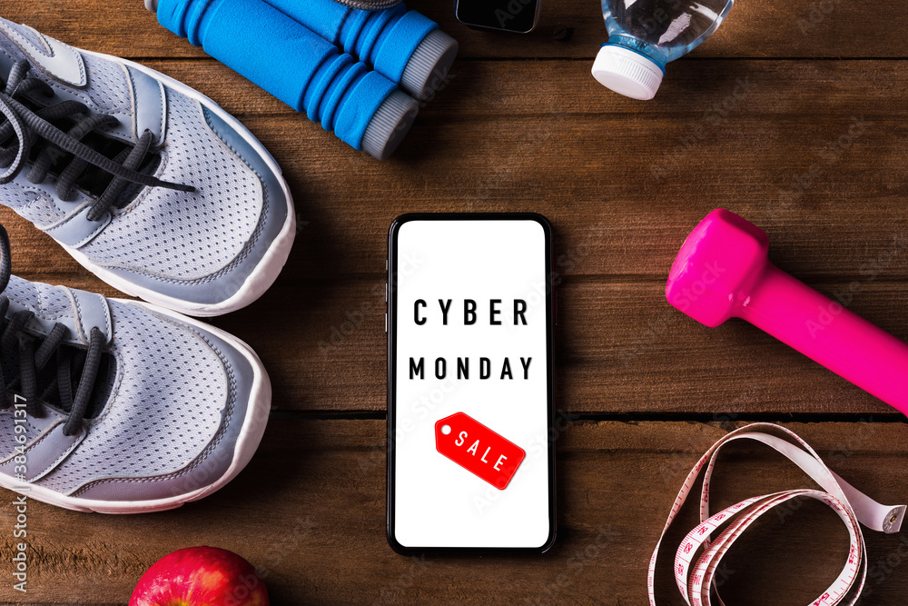 Cyber Monday sale concept with pair sports shoes, water, apple, jump rope  and smartphone blank screen on wood table, Gray sneakers and accessories  equipment in fitness GYM on wood table Stock-Foto