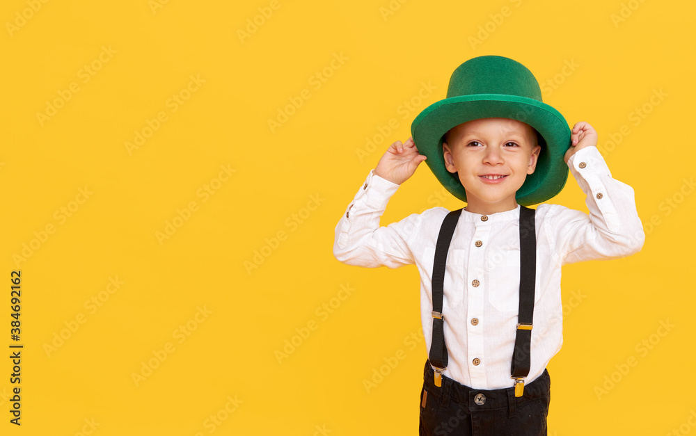 Smiling little child boy in green leprechaun hat on yellow background. St. Patrick Day celebration. Funny face Smiling little child boy in green leprechaun hat on yellow background. St. Patrick Day celebration. Funny face