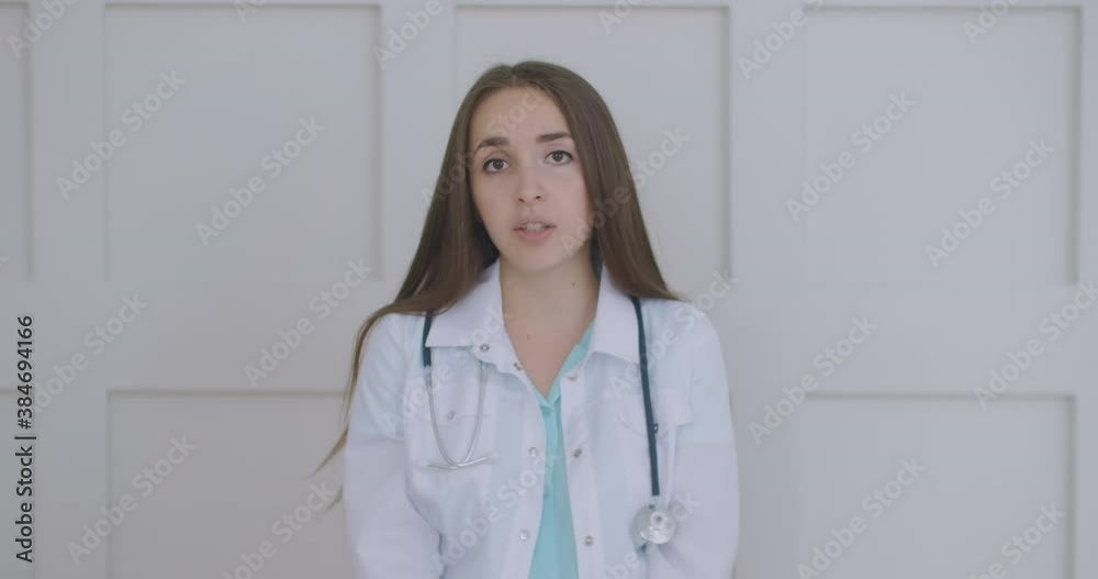 Smiling young female doctor wear white uniform stethoscope consulting online patient via video call looking at camera speaking cam do distance video chat, telemedicine and e-health concept, webcam