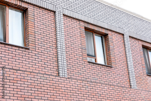 View of the brick building and windows. A brick is a type of block used to build walls, pavements and other elements in masonry construction.