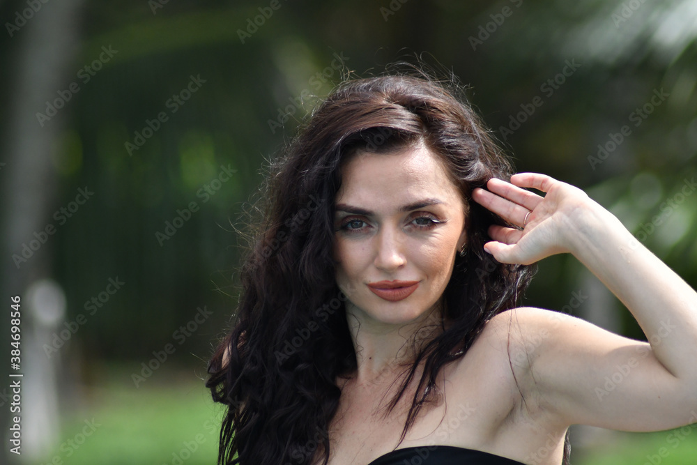 Natural cosmetics. Sensual woman against tropical leaves, looking at camera Natural cosmetics. Sensual woman against tropical leaves, looking at camera