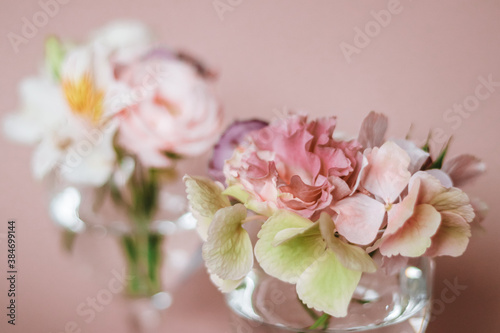 Fototapeta Naklejka Na Ścianę i Meble -  Cut flowers in glasses of water. Mini composition for table decoration.