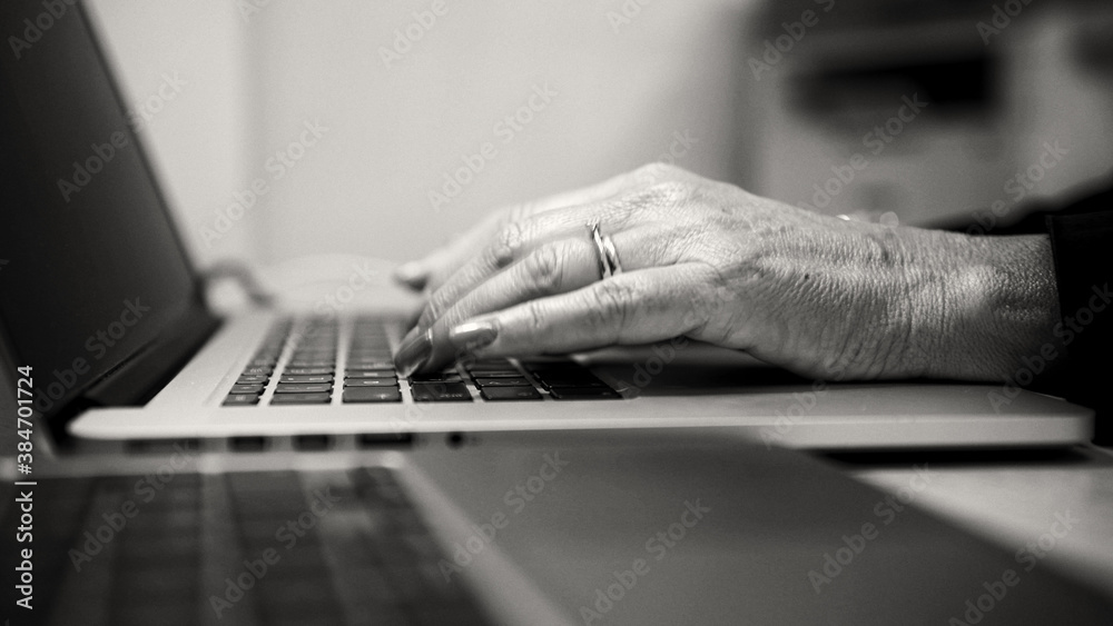 Woman hand working on a notebook using touchpad and keyboard, close up. Slow motion.