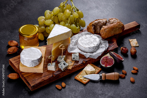 Beautiful delicious camembert cheese, parmesan, brie with grapes and figs