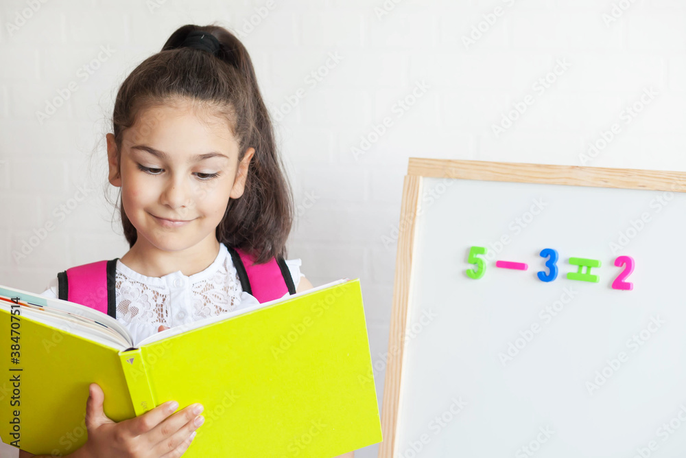Back to school. Happy cute schoolgirl near the blackboard. Education and school concept. Back to school. Happy cute schoolgirl near the blackboard. Education and school concept.