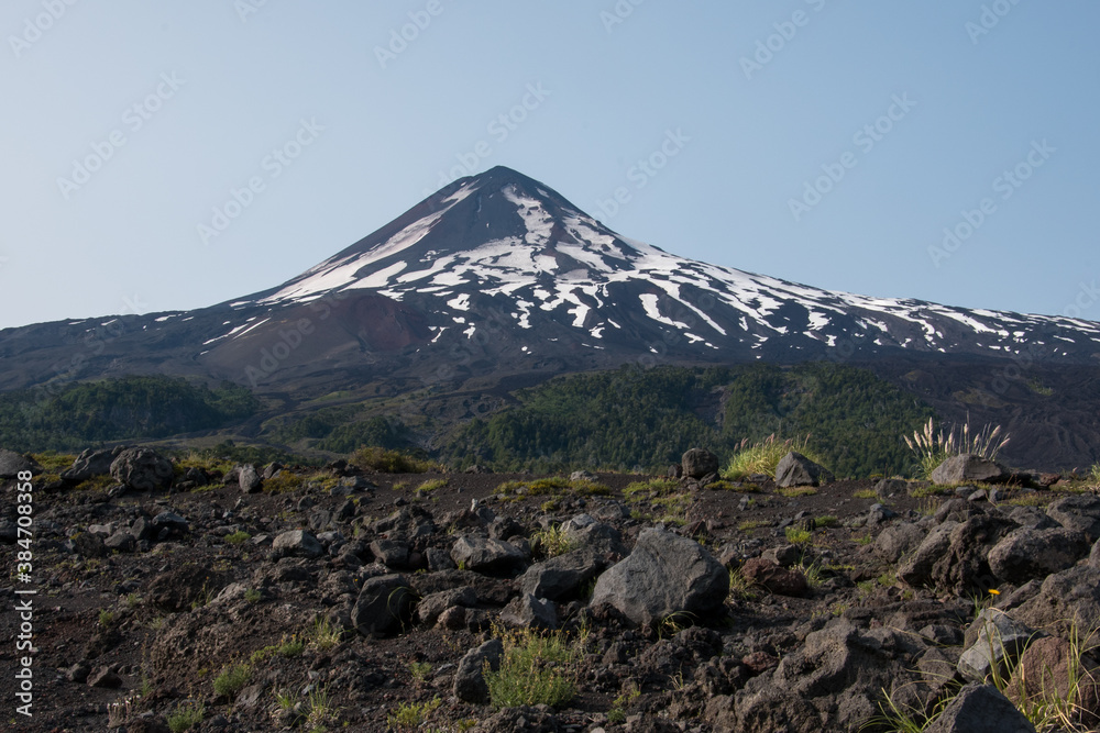 Fototapeta premium Vue sur un volcan enneigé en été au parc national de Conguillio au Chili