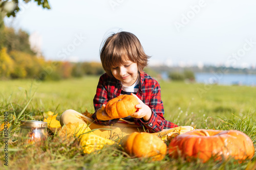 Φωτογραφία Cute boy play with pumpkin in autumn park on Halloween