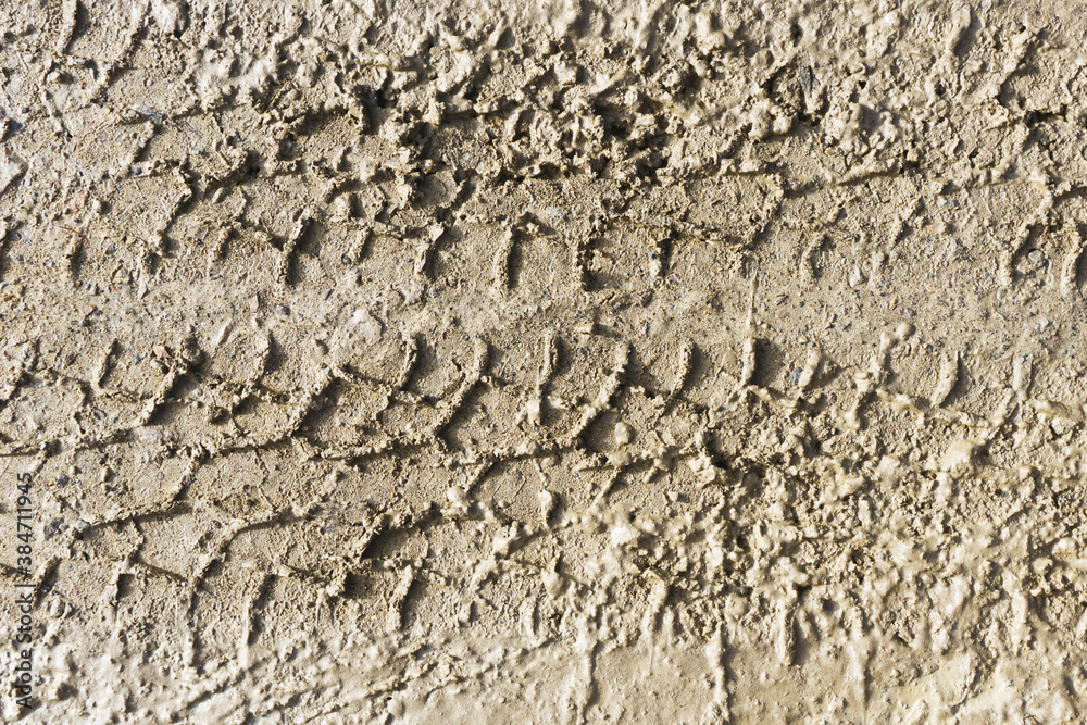Mud tyre mark background. Wet sand tire print texture. Car trail track pattern. Mountain road after rain. Slippery terrain dangerous weather conditions. Mud tyre mark background. Wet sand tire print texture. Car trail track pattern. Mountain road after rain. Slippery terrain dangerous weather conditions.