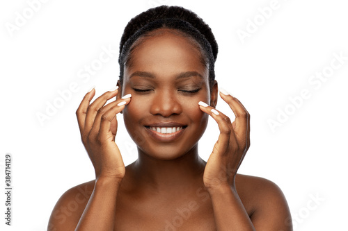 beauty, skin care and people concept - portrait of happy smiling young african american woman with bare shoulders over white background