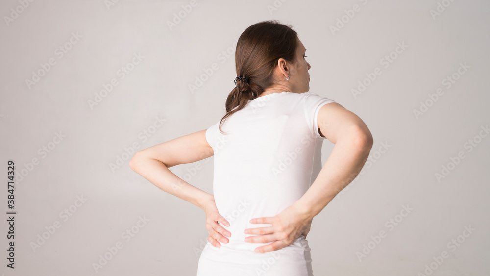 Tired woman feeling neck pain, massaging tense muscles. back pain and lower back view Tired woman feeling neck pain, massaging tense muscles. back pain and lower back view