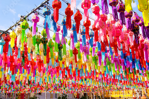 Festival paper lanterns , colorful lamp hanging on line rope blue sky background , decorations for celebration loy krathong festival in Wat Phra That Hariphunchai woramahawihan lamphun of Thailand