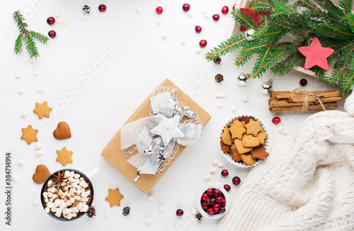 Fototapeta Naklejka Na Ścianę i Meble -  Christmas decoration, cup of coffee, homemade sweet gingerbread cookies, pine cones and branches on white wooden background.