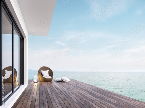 Minimal style room terrace with sea view 3d render,There has dark wooden floors,decorated with rattan furniture and white lantern ,overlooking the sea and sky. photo