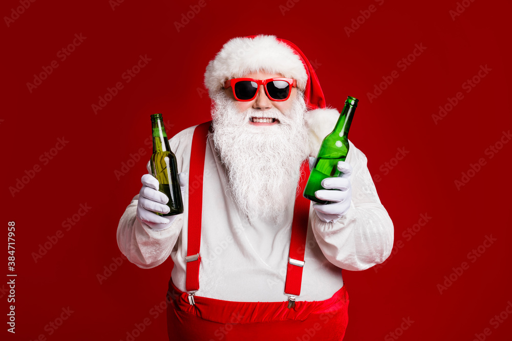 Portrait of his he attractive cheerful cheery funny fat white-haired Santa holding in hand beer bottles invite festal event isolated bright vivid shine vibrant red burgundy maroon color background - obrazy, fototapety, plakaty 