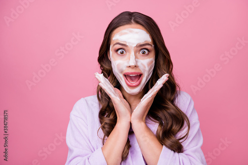 Photo portrait of happy amazed girl keeping hands near face with hydrating foam before applying makeup isolated on pink color background