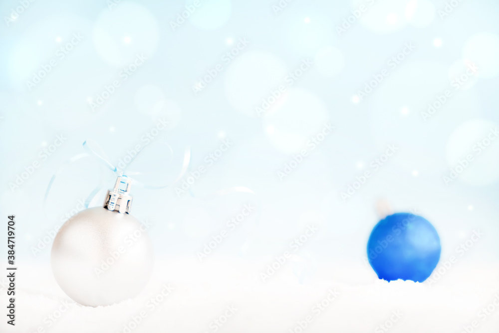Fototapeta premium Christmas balls on surface with snow and defocused lights with copy space