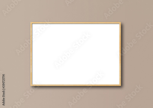 Wooden picture frame hanging on a beige wall