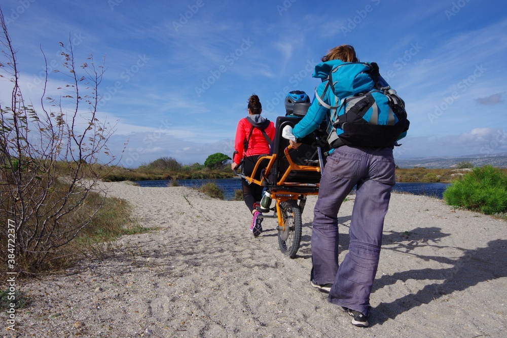 © Ourson+ - Randonnée solidaire avec handicap en joelette sorte de fauteuil roulant pour aider un handicapé à aller dans la nature
