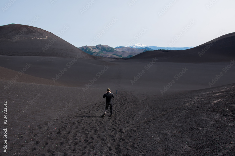 Homme marchant dans un paysage désertique et volcanique au Chili