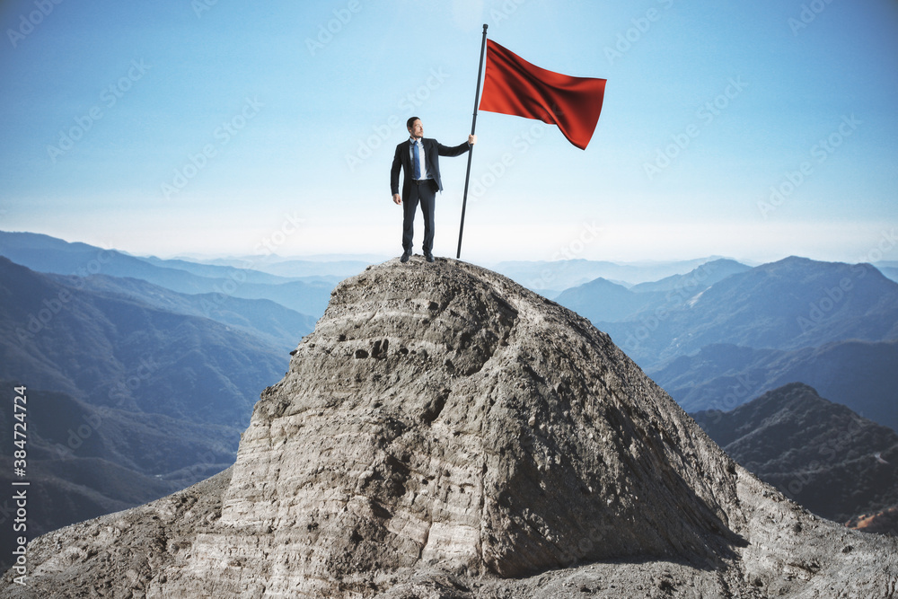 Obraz premium Businessman with red flag standing on mountain top.
