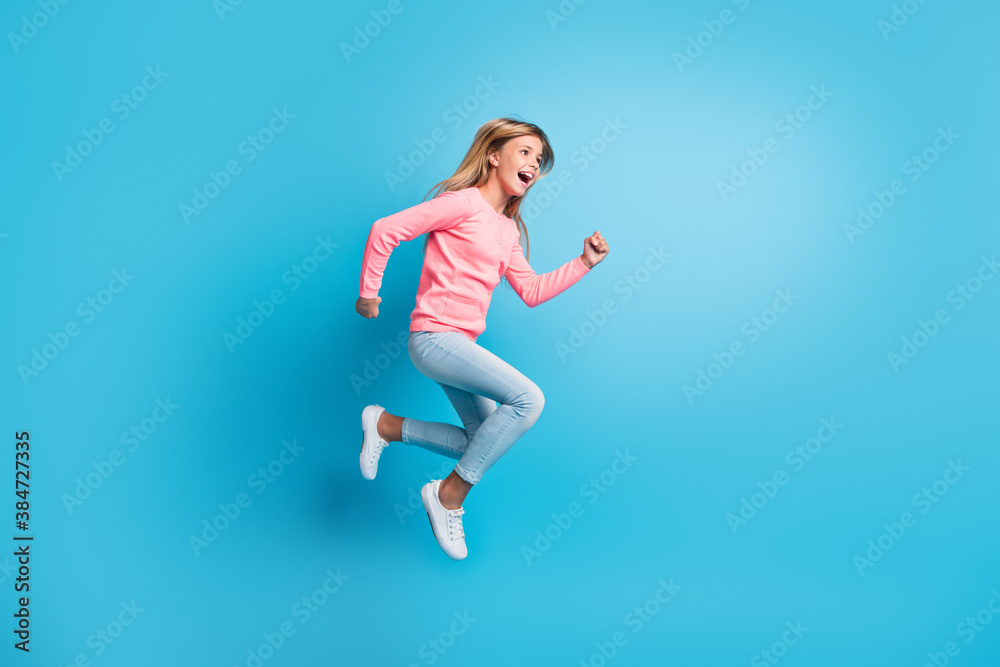 Photo portrait of girl jumping up running isolated on pastel blue colored background