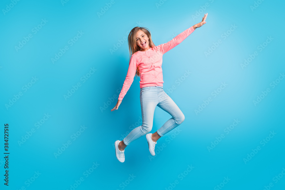 Photo portrait of girl jumping up making plane with hands isolated on pastel blue colored background Photo portrait of girl jumping up making plane with hands isolated on pastel blue colored background