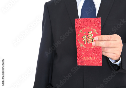 Male in suit and leather shoes holding red envelope