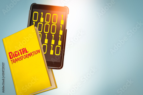 Image of Yellow Book and a Tablet Computer showing the Text Transformation