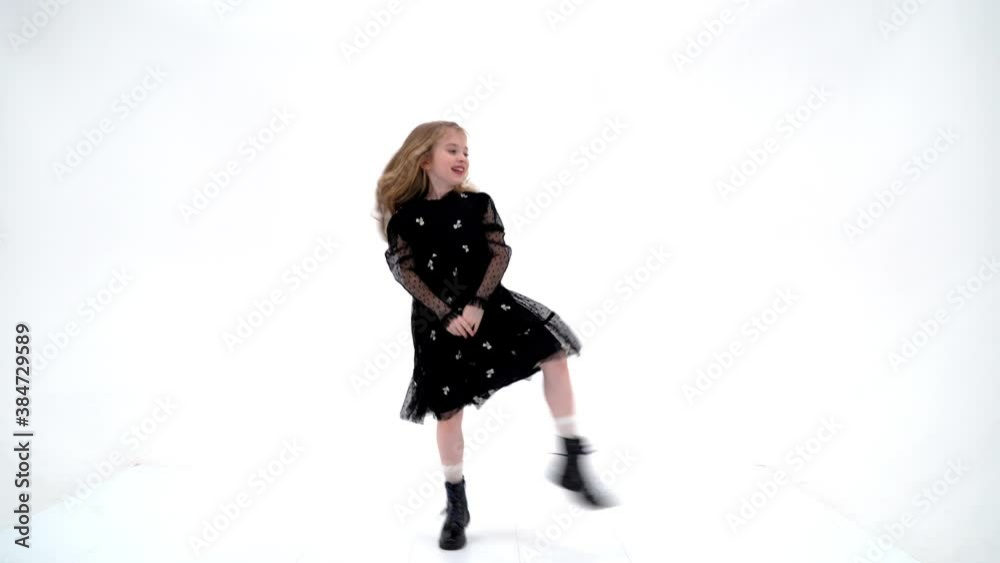 A cheerful little girl is dancing.The concept of a school of dance. A cheerful little girl is dancing.The concept of a school of dance.