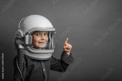 Photographie A small child imagines himself to be an astronaut in an astronaut's helmet