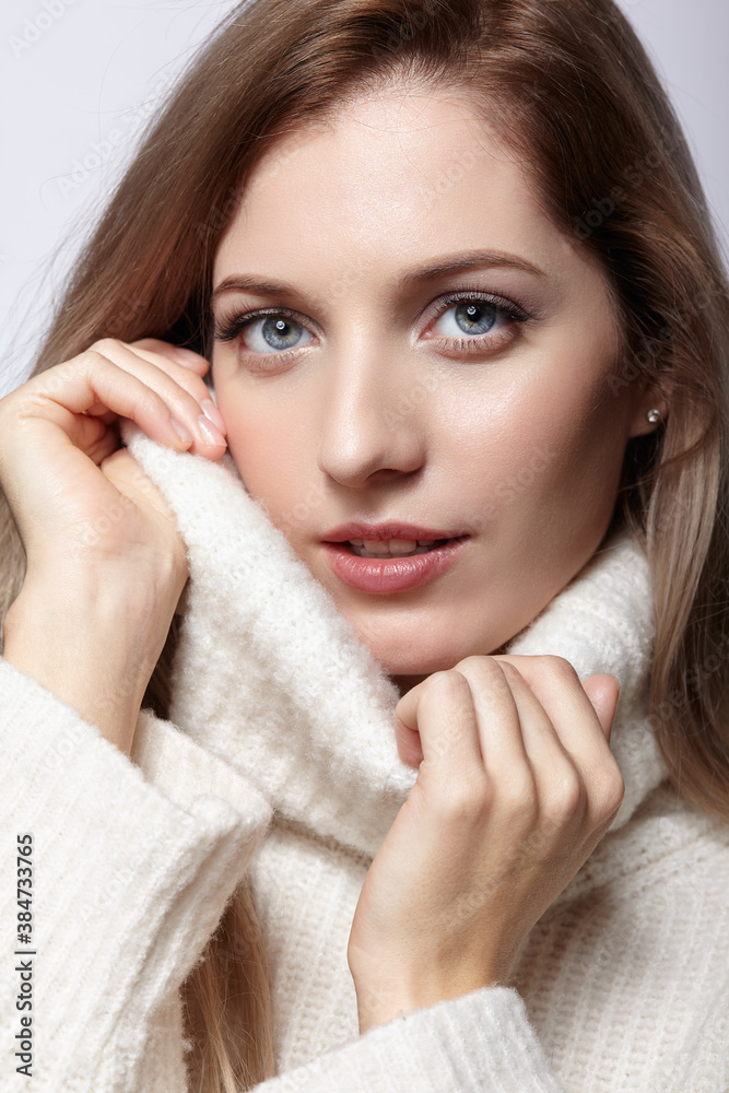 Blonde young beautiful woman dressed in white woolen sweater . Blonde young beautiful woman dressed in white woolen sweater .