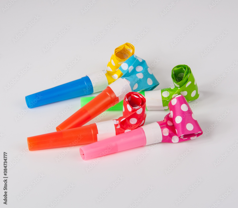 Rolled festive noisemaker or party whistle on the white Rolled festive noisemaker or party whistle on the white