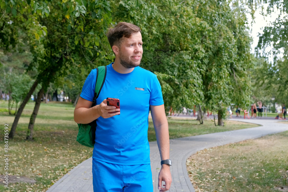 Attractive runner in blue sportswear using smartphone checking fitness results. Attractive runner in blue sportswear using smartphone checking fitness results.