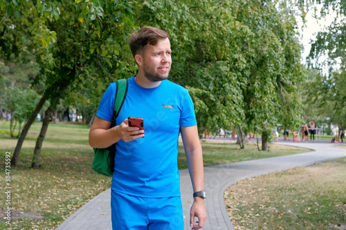 Attractive runner in blue sportswear using smartphone checking fitness results. © evelinphoto