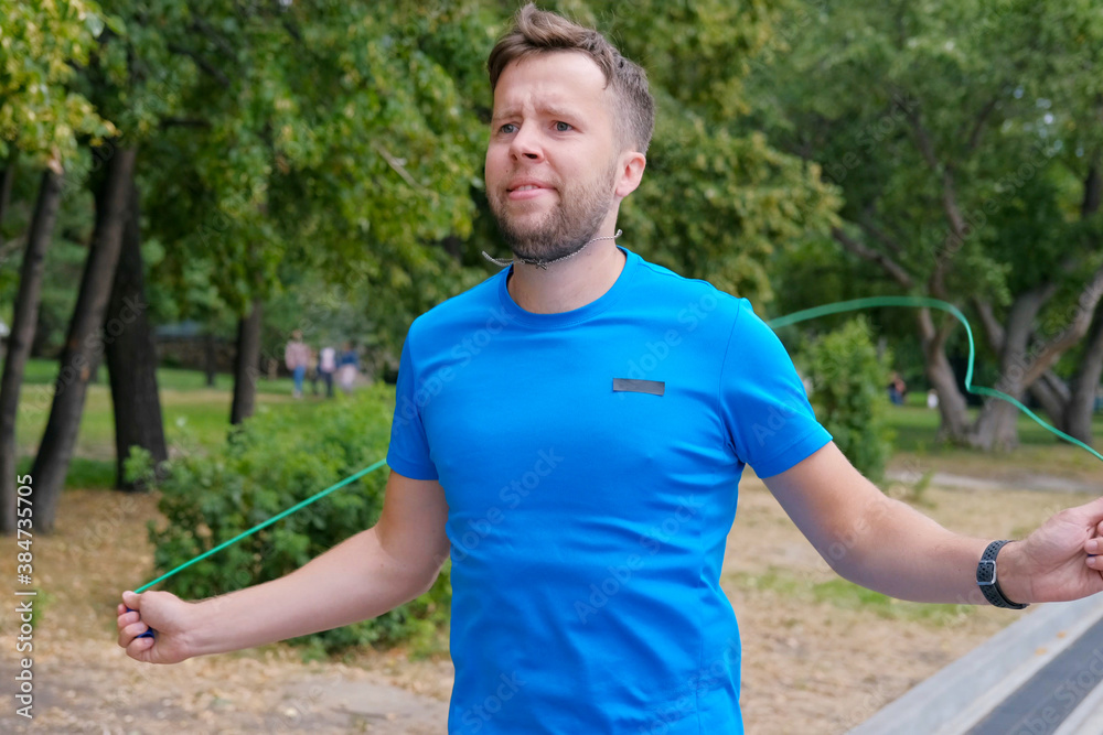 An athlete jumps on a rope before running, jogging.The man doing on workout training exercises. An athlete jumps on a rope before running, jogging.The man doing on workout training exercises.