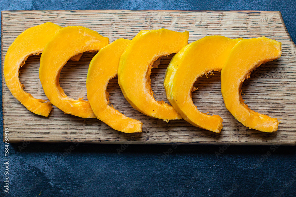 pumpkin ready to eat raw  preparation pieces slices for baking or cooking on the table tasty serving size portion top view copy space for text food background rustic