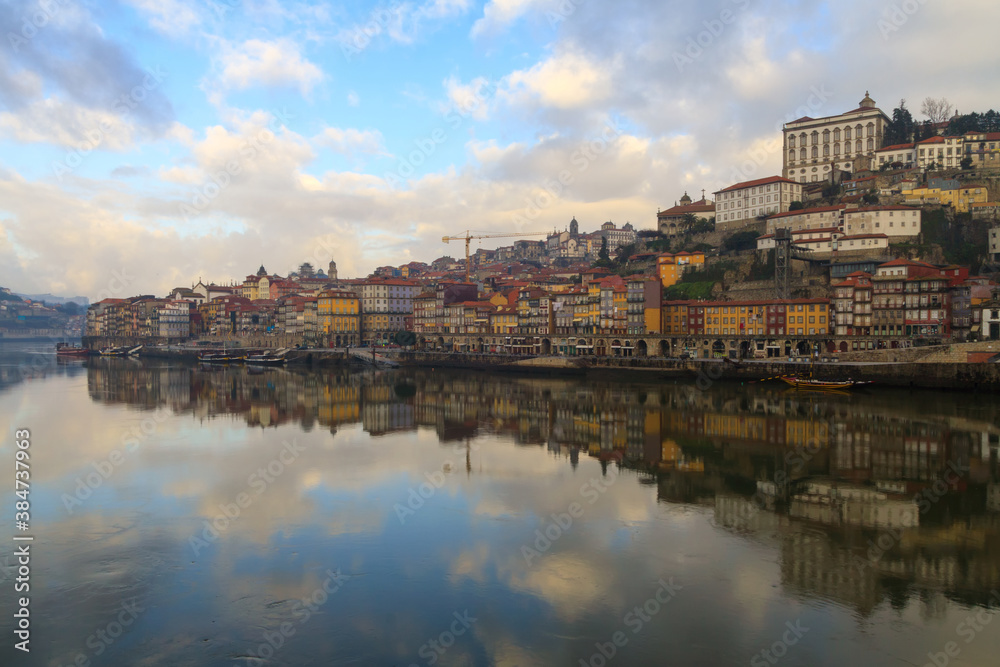 Porto, Portugal panoramic cityscape on the Douro River at sunset. Urban landscape at sunset with traditional boats of Oporto city. Downtown and historic center, travel destination. Oporto landmark.