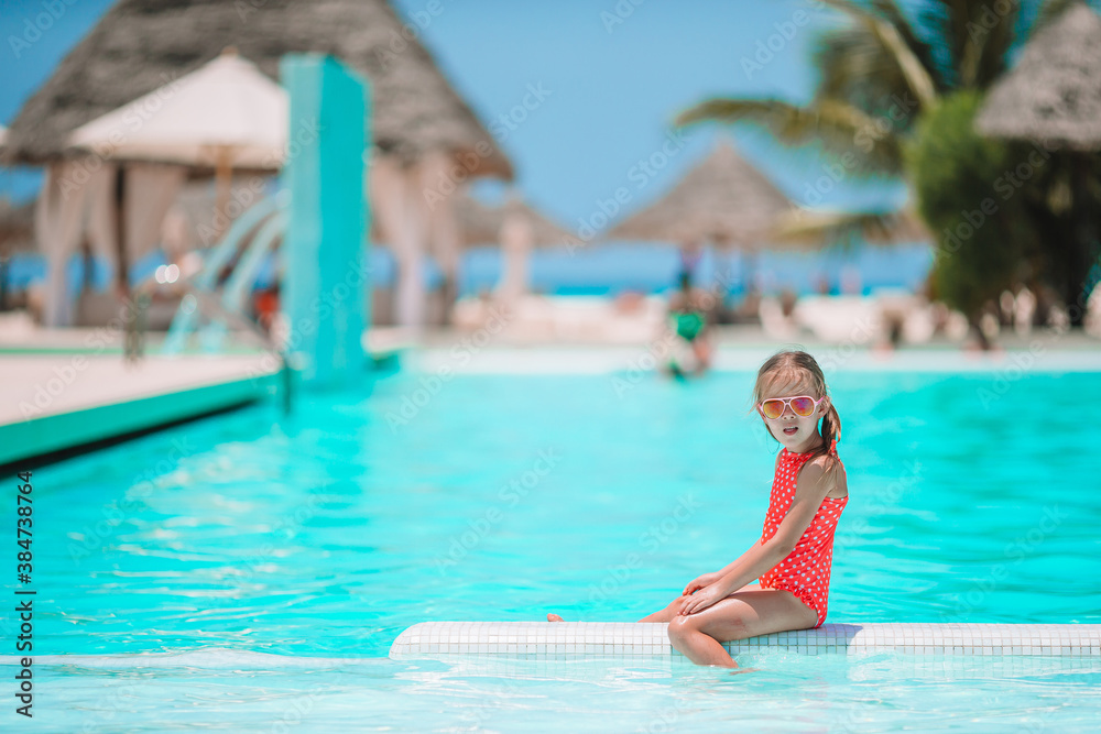 Little adorable girl in outdoor swimming pool