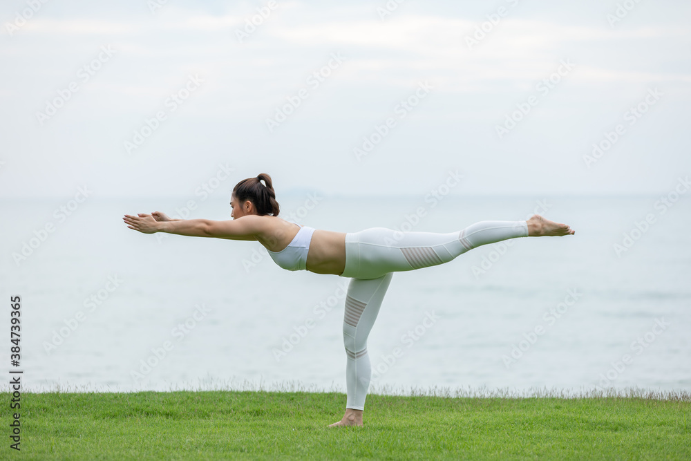 Healthy Asian woman practicing yoga Balancing stick Pose stretching exercises muscle for warm up on the beach in thailand Healthy Asian woman practicing yoga Balancing stick Pose stretching exercises muscle for warm up on the beach in thailand