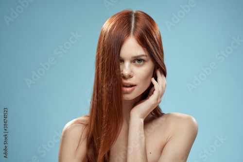 Woman with naked shoulders long hair hairstyle care charm blue background