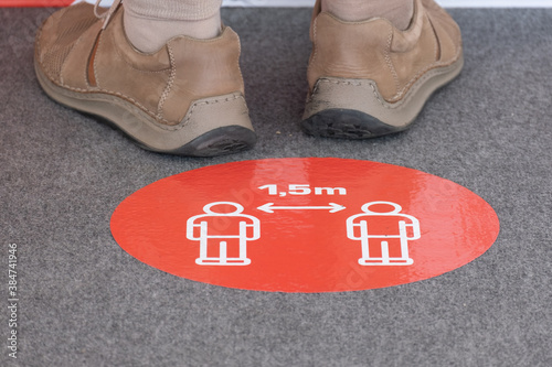 Red round sign printed on ground informing people to keep 1,5 meter distance from each other,prevent spreading Coronavirus COVID-19 virus disease infection