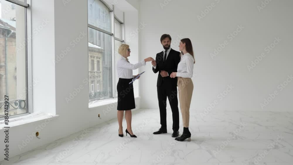 Real-estate Agent Shows New Apartments to Couple and giving the keys to a man. Real-estate Agent Shows New Apartments to Couple and giving the keys to a man.