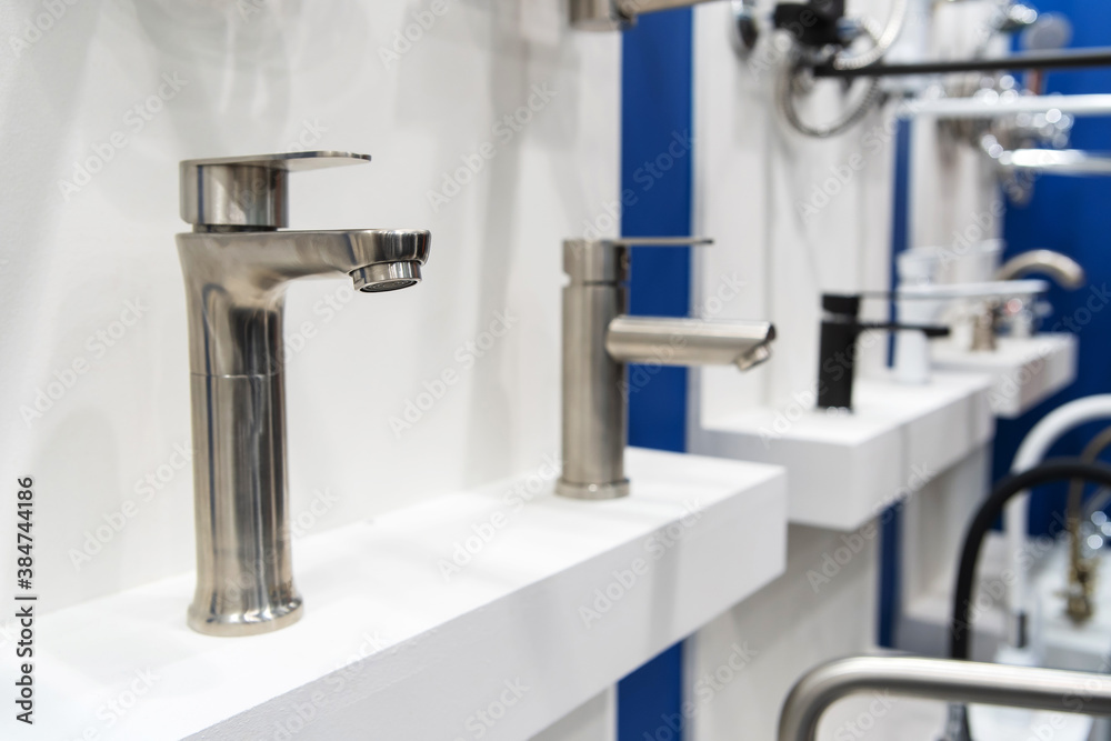 Lots of water taps. Sale of chrome bathtub taps in a plumbing shop. Lots of water taps. Sale of chrome bathtub taps in a plumbing shop.