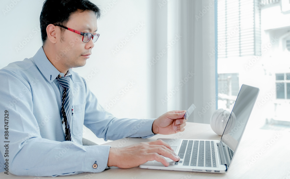 Businessman use credit card to online shopping from home with laptop, payment e-commerce, internet banking, spending money for next holidays Businessman use credit card to online shopping from home with laptop, payment e-commerce, internet banking, spending money for next holidays