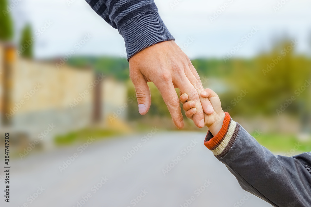 A beautiful hands of parent and child outdoors in the park