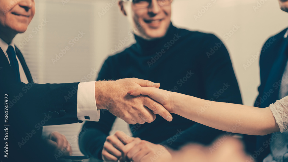 serious businessman shaking hands with a young business man