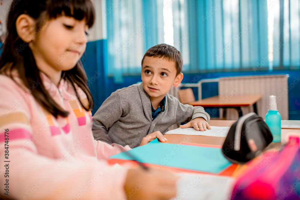 Elementary schoolchildren writing at the desk in the classroom. Elementary schoolchildren writing at the desk in the classroom.