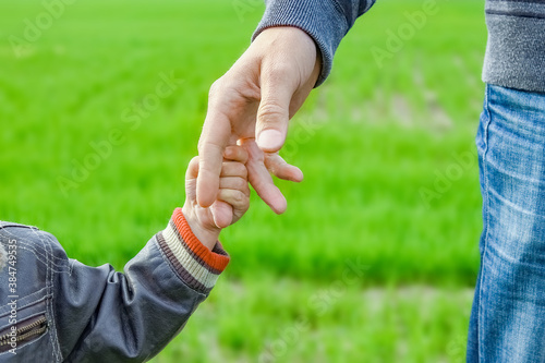 A beautiful hands of parent and child outdoors in the park